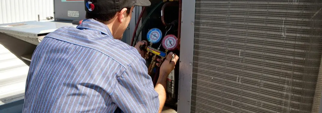 HVAC technician servicing a condenser unit in Grant-Valkaria